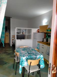 een keuken met een tafel en stoelen in een kamer bij Villa bouganville splendido appartamento in Olbia