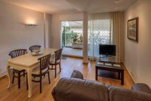 a living room with a table and a couch at Ático con gran terraza en el corazón de Girona in Girona