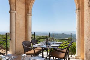 a dining room table with a balcony overlooking the ocean at Santuari de Cura in Randa