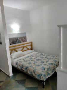 een slaapkamer met een bed met een blauw en wit dekbed bij Villa bouganville splendido appartamento in Olbia