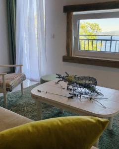 a living room with a table and a window at Apartmani VERONA in Bijela