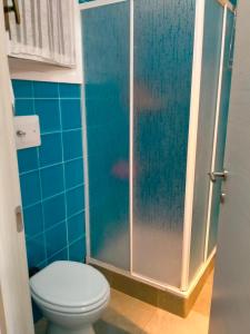 een badkamer met een toilet en een glazen douche bij Villa bouganville splendido appartamento in Olbia
