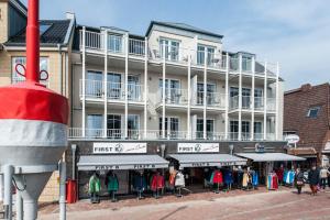 ein großes weißes Gebäude mit Menschen, die davor gehen in der Unterkunft Weisse Villa Apartment 2 3 Deichkind in Büsum + 4 Fotos