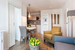 a living room and kitchen with a couch and a table at Weisse Villa Apartment 2 4 Estelles Beachhouse in Büsum