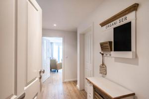 a living room with a tv and a hallway at Weisse Villa Apartment 2 4 Estelles Beachhouse in Büsum