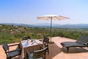a table with chairs and an umbrella on a patio at Costiera del Cilento Apartments in Casal Velino