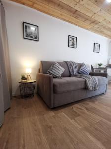 un sofá en una sala de estar con techo de madera en Affaires ou Loisirs - La Cachette Secrete, en Choisy-le-Roi