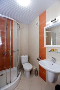 a bathroom with a toilet and a sink and a shower at Coral Hotel in Pomorie