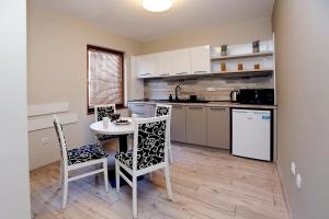 a kitchen with a table and two chairs and a table at Coral Hotel in Pomorie