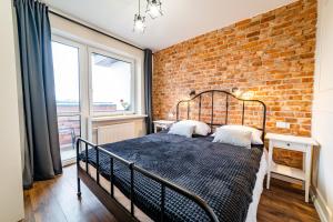a bedroom with a brick wall and a bed at Apartament z Widokiem in Mikołajki
