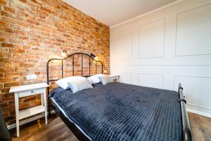 a bed in a room with a brick wall at Apartament z Widokiem in Mikołajki