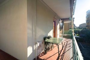 a balcony with a green table and chairs on a building at [PIETRA LIGURE] The apartment for your vacations. in Pietra Ligure