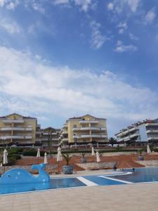 a swimming pool in front of some apartment buildings at Apartment with a sea view in Skiper resort in Crveni Vrh