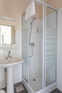 La salle de bains est pourvue d'une douche et d'un lavabo. dans l'établissement Hotel le Chamois by YourAlpAdventure, à Huez