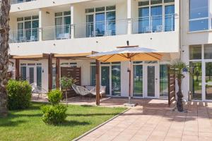 a patio with an umbrella in front of a building at Azul Beach Resort Montenegro by Karisma - All Inclusive in Ulcinj