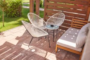 three chairs and a table and a couch on a patio at Azul Beach Resort Montenegro by Karisma - All Inclusive in Ulcinj
