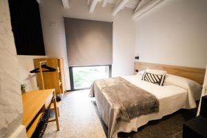 1 dormitorio con cama y ventana grande en Apartamentos Mk77 León - LaHoz, en León