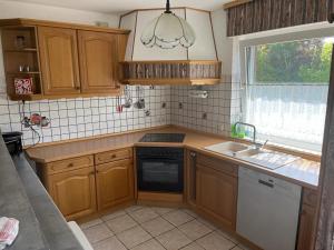 a kitchen with wooden cabinets and a sink and a window at Wattenküste in Dorum