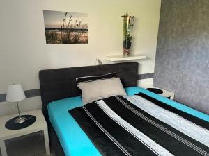 a bedroom with a bed with a black and blue at Wattenküste in Dorum