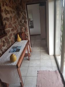 a room with a table and a stone wall at Croc Lapa Chalet in Malelane