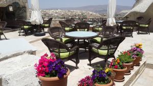 patio ze stołem, krzesłami i kwiatami w obiekcie Arif Cave Hotel w Göreme