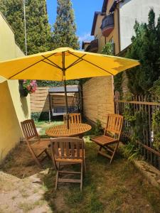 a table and chairs under a yellow umbrella at Willa Aldona in Jastrzębia Góra