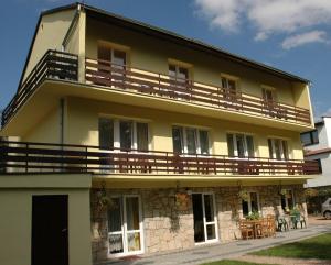 a building with a balcony on top of it at Villa Laura in Polanica-Zdrój