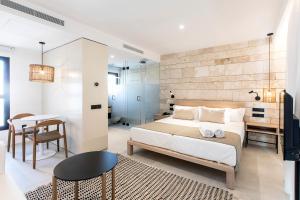 a bedroom with a bed and a desk and a table at Can Micalet in La Savina