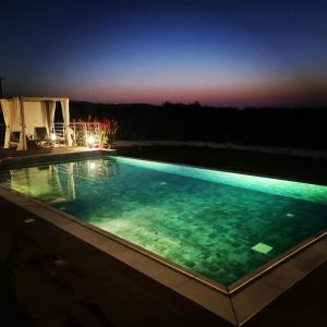 uma piscina iluminada à noite em Eva Luxury Villa em Lachi
