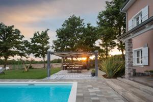 a backyard with a pergola and a swimming pool at Villa Green Frame in Butkovići