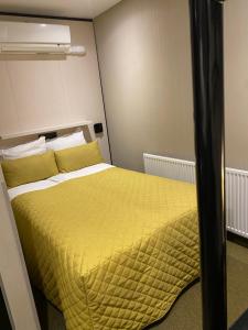 a bedroom with a bed with a yellow blanket at Cityview Hotel in Amsterdam