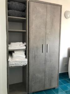 d'une armoire grise avec des serviettes blanches dans la salle de bains. dans l'établissement Il Carrubo, à Vietri
