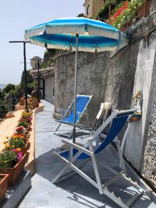 - 2 chaises et un parasol sur la terrasse dans l'établissement Il Carrubo, à Vietri