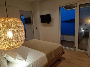 um quarto com uma cama e um lustre em 9 Muses Apartments em Agios Nikolaos