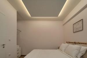 a white bedroom with a bed and a ceiling at My Oneiro City Apartments in Ioannina