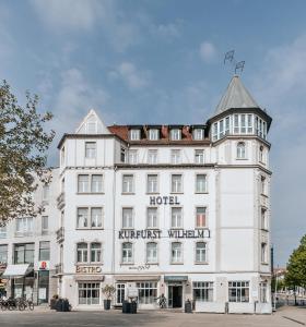 カッセルにあるベストウエスタン ホテル クアフュアスト ヴィルヘルム I.の看板が貼られた白い大きな建物