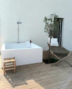 bañera blanca en una habitación con árbol en JOA guesthouse, entre Bayonne et océan en Boucau