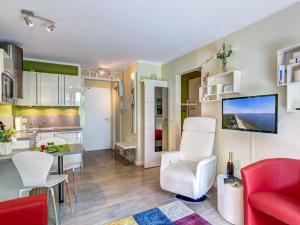 ein Wohnzimmer mit einem roten Sofa und einer Küche in der Unterkunft Residenz am Balmer See - BS 46 mit Wellnessbereich in Balm