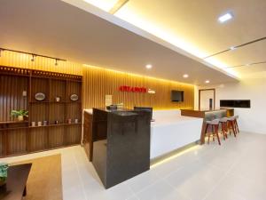 een lobby met een witte balie en een gele muur bij Ariano's Inn in Butuan