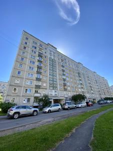 a large building with cars parked in front of it at Spacious 3-Room Apartment & Residential Parking in Rīga