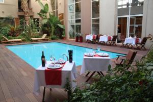 ein Restaurant mit zwei Tischen und einem Pool in der Unterkunft Casablanca Suites & Spa in Casablanca