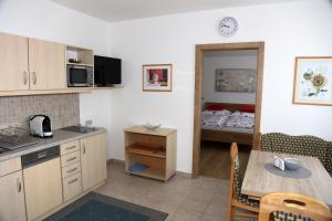 a kitchen with a table and a room with a bed at Ferienwohnungen Wegleitner Erich und Michaela in Illmitz