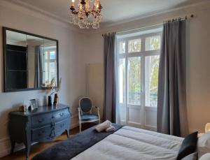 a bedroom with a bed and a desk and a mirror at Le Ness - Face au Pont des Amours - Majord'Home in Annecy