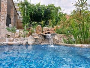 a swimming pool with a waterfall in a backyard at Apartmani VERONA in Bijela
