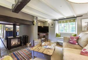 a living room with a fireplace and a couch at Jasmine Cottage in Iwerne Minster