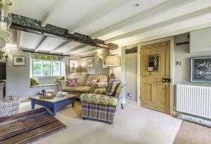 a living room with a couch and a table at Jasmine Cottage in Iwerne Minster