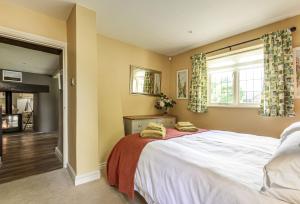 a bedroom with a large bed and a fireplace at Jasmine Cottage in Iwerne Minster