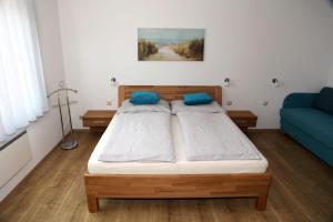 a bedroom with a bed and a blue couch at Ferienwohnungen Wegleitner Erich und Michaela in Illmitz