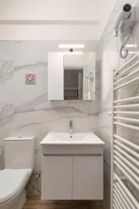 Baño blanco con lavabo y aseo en My Oneiro City Apartments, en Ioannina