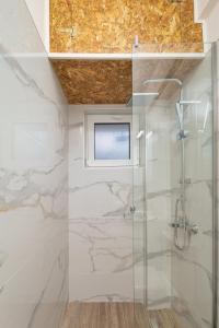 a bathroom with a shower and a television on the ceiling at My Oneiro City Apartments in Ioannina